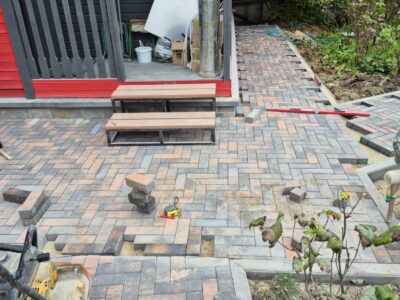 Paving installation in progress around entrance steps