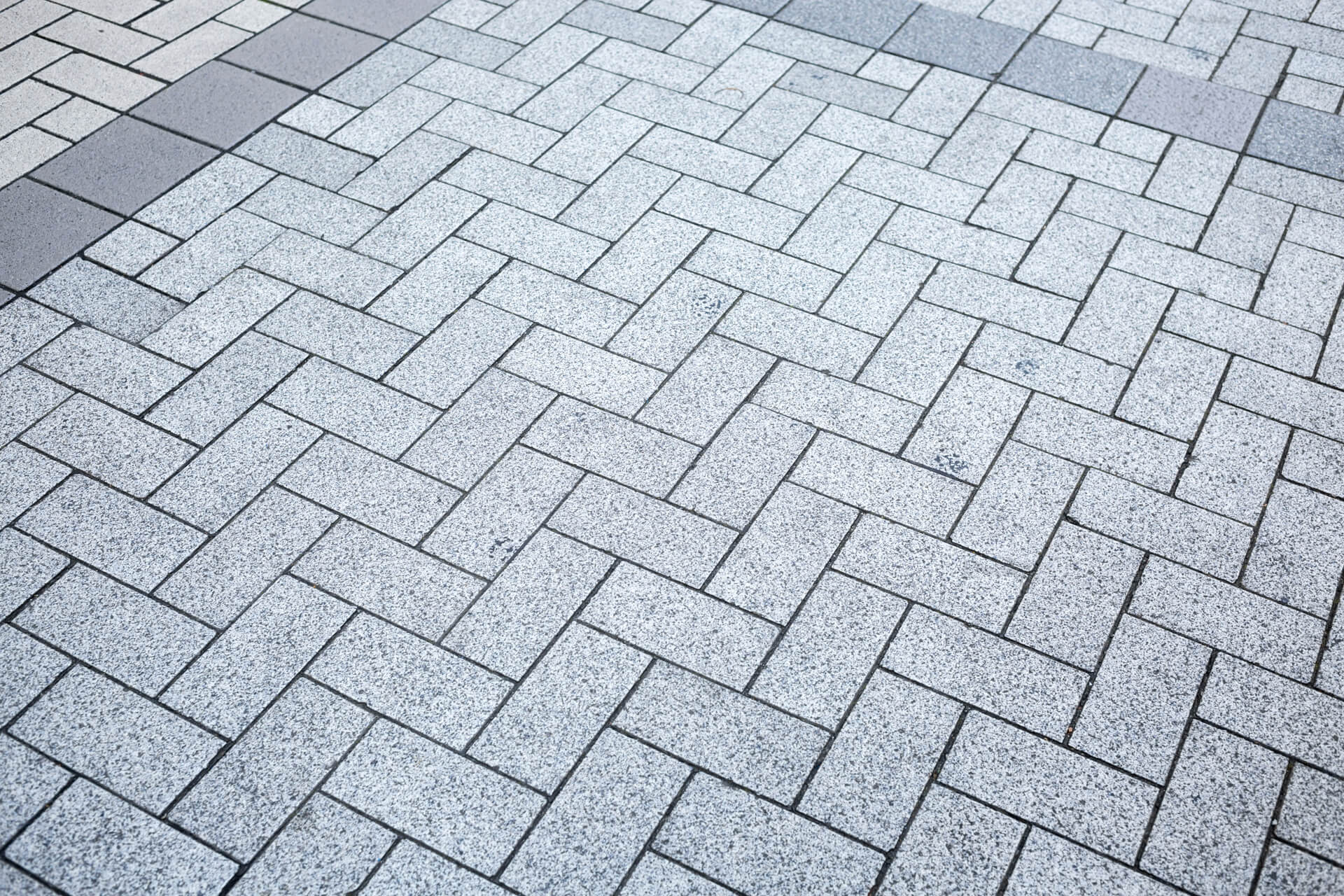 Close view of grey paving blocks with neat joints and charcoal accents